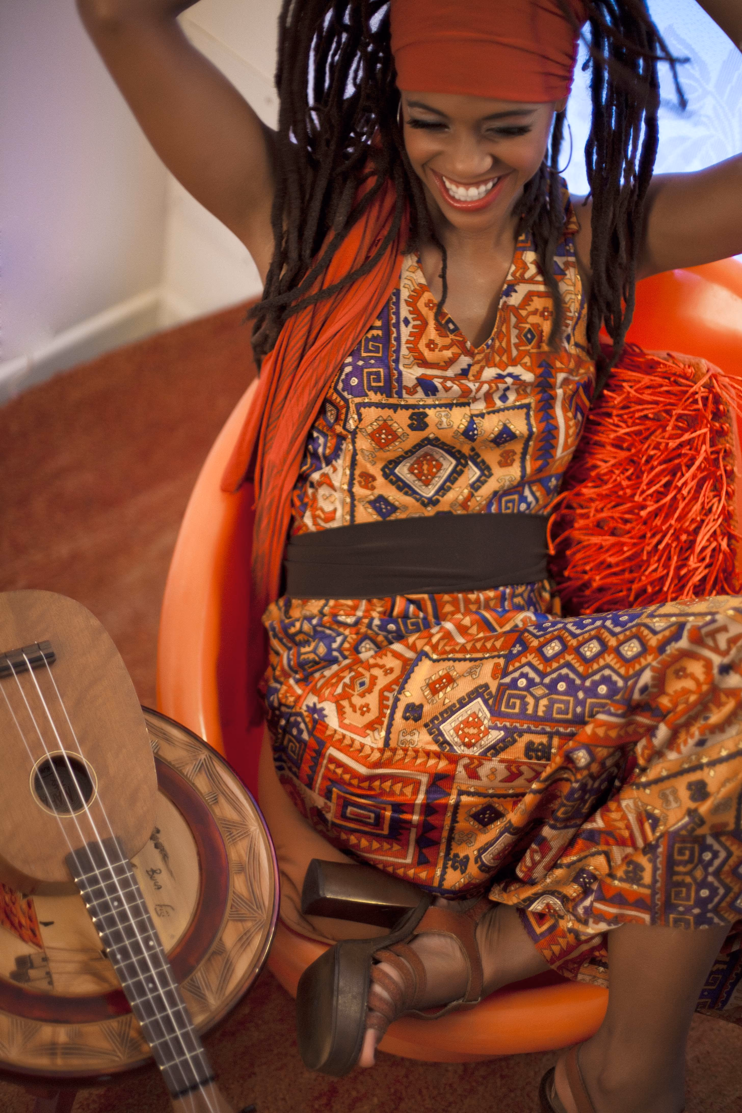 Miss Renee Simone laughing, seated in an orange chair