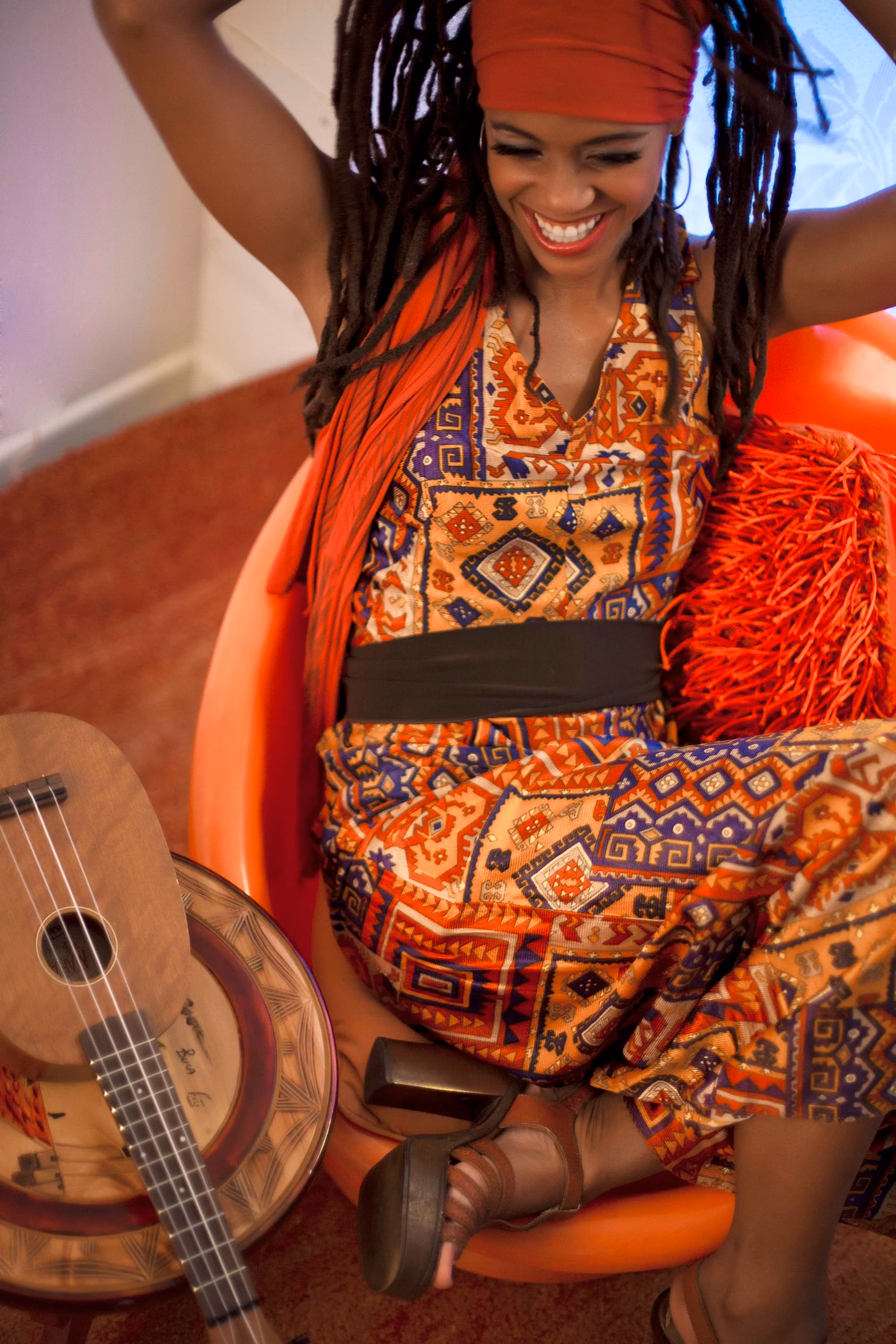 Miss Renee Simone laughing, seated in an orange chair