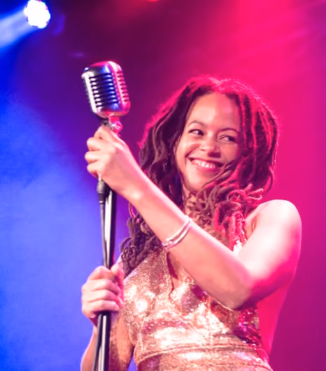 Miss Renee Simone on stage supporting Morcheeba, gold sequin dress and microphone